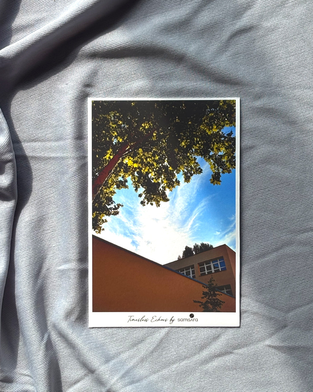 Poster of a tree and building on a gray fabric background