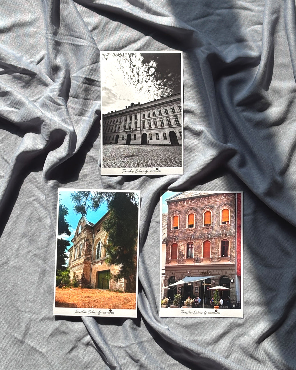 A set of three postcards featuring architectural photography laid out on a grey surface.