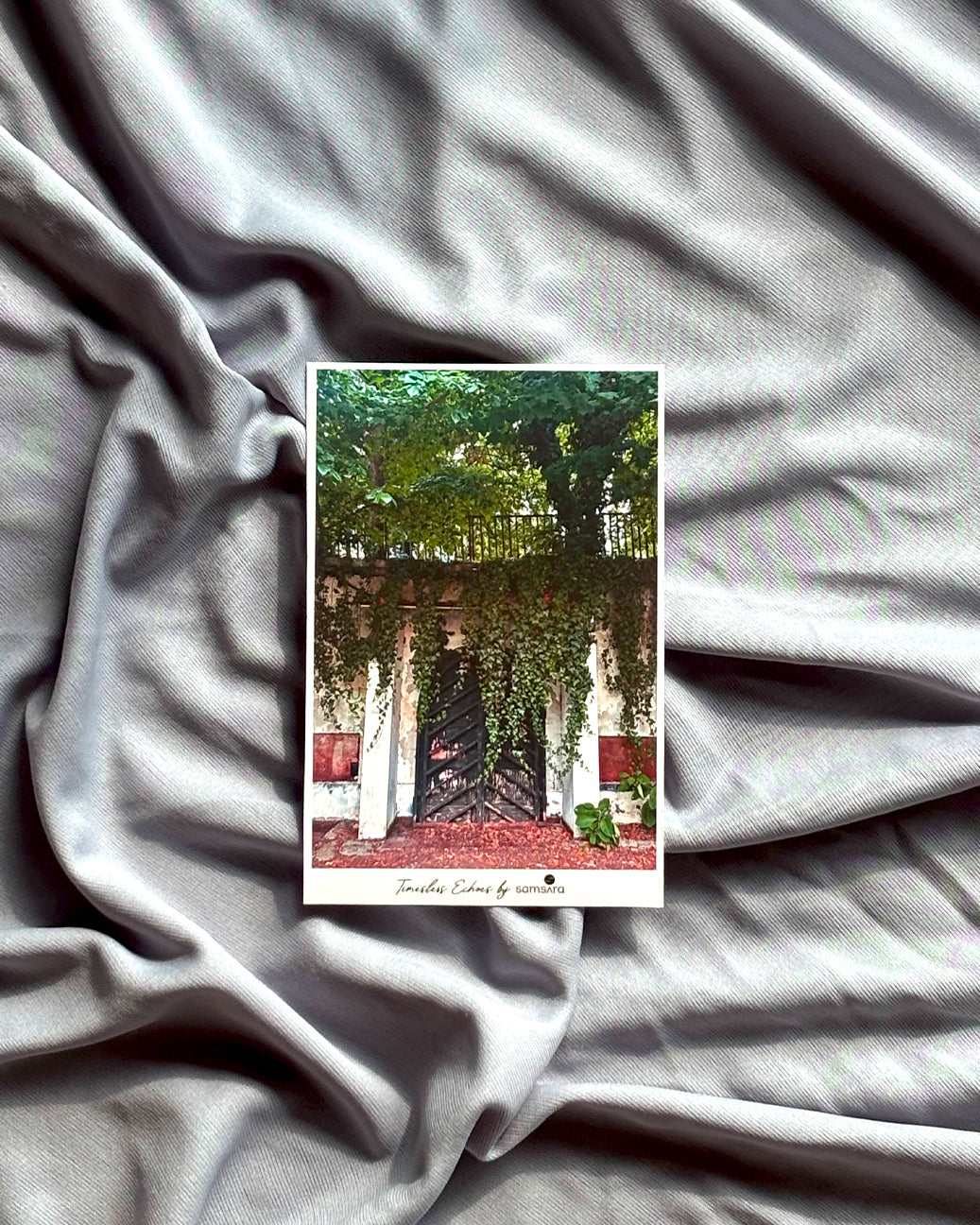 Small card with a scenic design on a textured gray fabric background