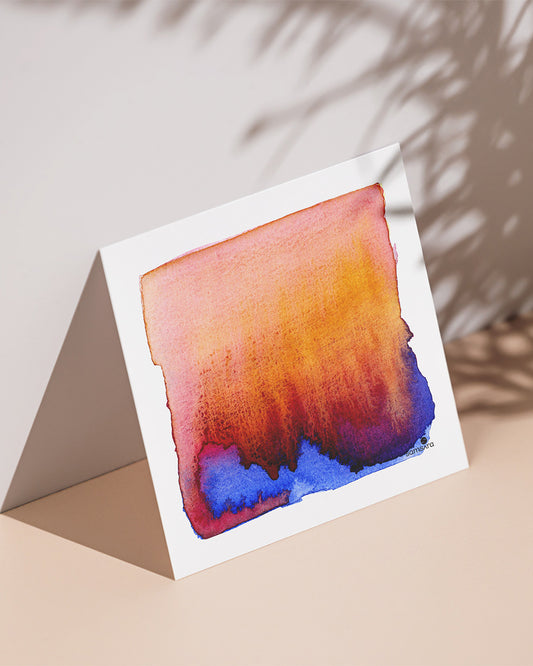 An art print with a abstract watercolor painting in blue and orange hues on the front.