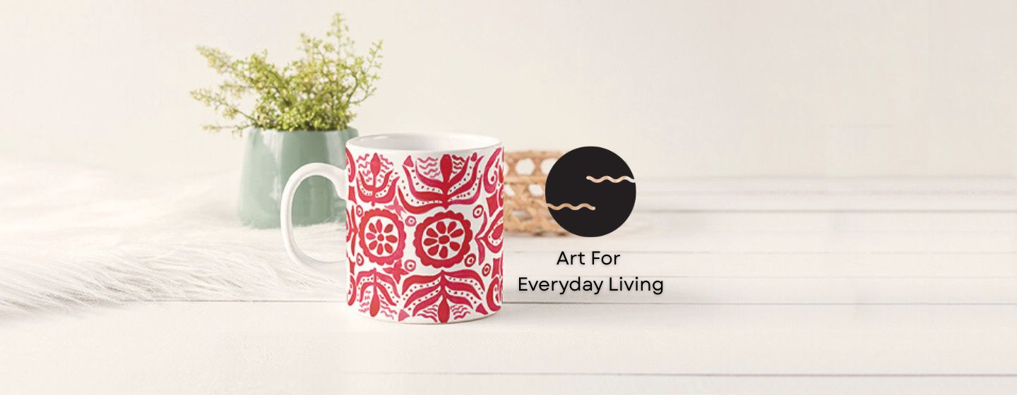 Decorative mug with red pattern on a light wooden surface.