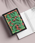 Floral botanical notebook displayed open with coral flower cover design - artistic spiral-bound journal
