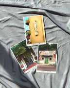 A set of three framed art prints laid out on a grey surface, featuring architectural details such as doorways and a statue.