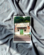 Vintage-style postcard with a house with green door on textured gray background