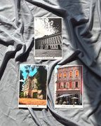 A set of three postcards featuring architectural photography laid out on a grey surface.