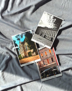 A set of three postcards featuring architectural photography laid out on a grey surface.