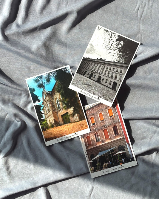 A set of three postcards featuring architectural photography laid out on a grey surface.