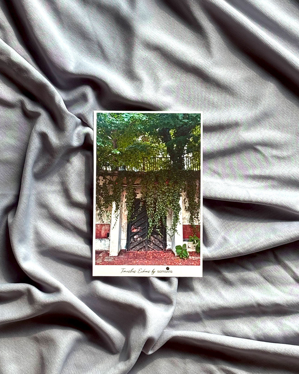 Small card with a scenic design on a textured gray fabric background