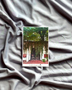 Small card with a scenic design on a textured gray fabric background